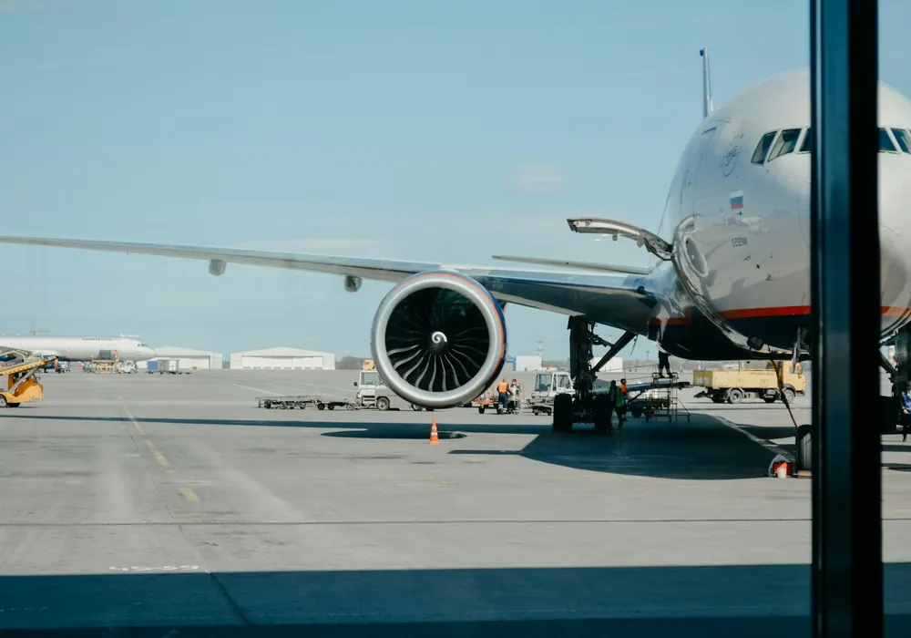 Avión comercial en plataforma aeroportuaria durante operaciones de carga aérea