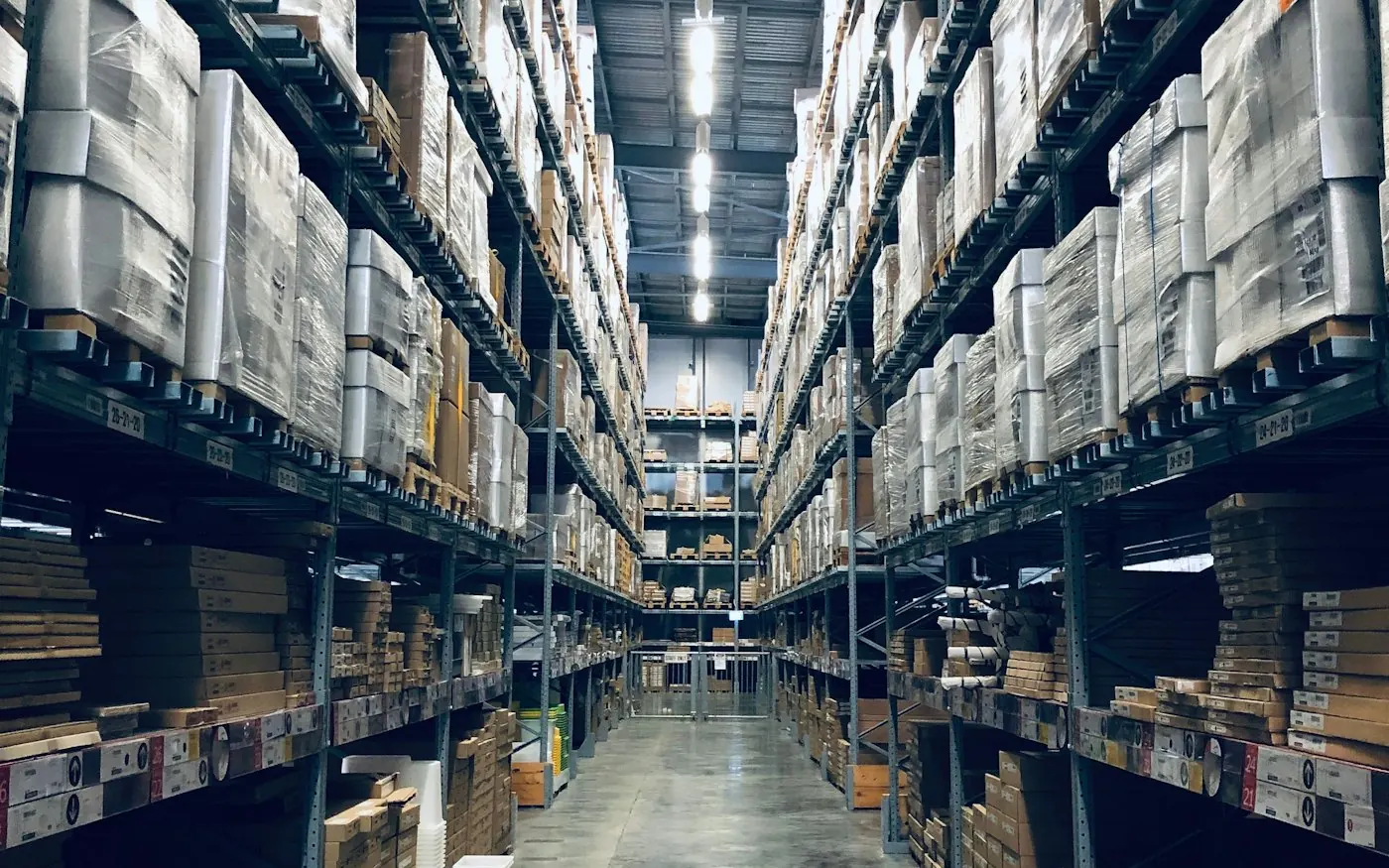 Operación logística en bodega con estanterías y paquetes listos para recepción